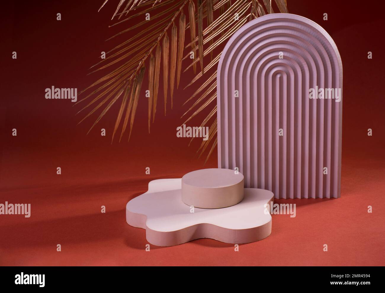 Composizione di podi geometrici o di colonnine di colore rosa sporco contro il rosso. Sfondo minimo per la visualizzazione della presentazione del prodotto cosmetico. Foto Stock