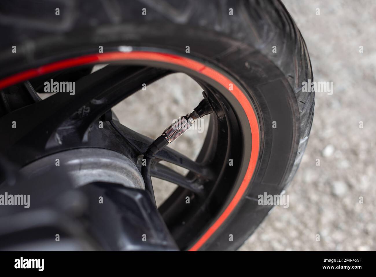 una ruota motobike con un compressore d'aria collegato per gonfiare la pressione dei pneumatici. Foto Stock