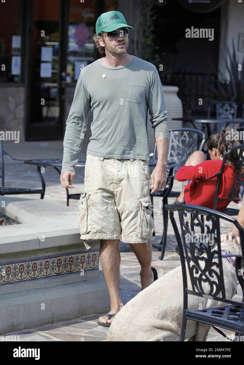 Gerard Butler in un cappello verde da baseball, t shirt e pantaloncini è  visto dirigersi verso un locale pizzeria per un boccone da mangiare.  Mescolandosi come locale di Malibu, Butler si ferma