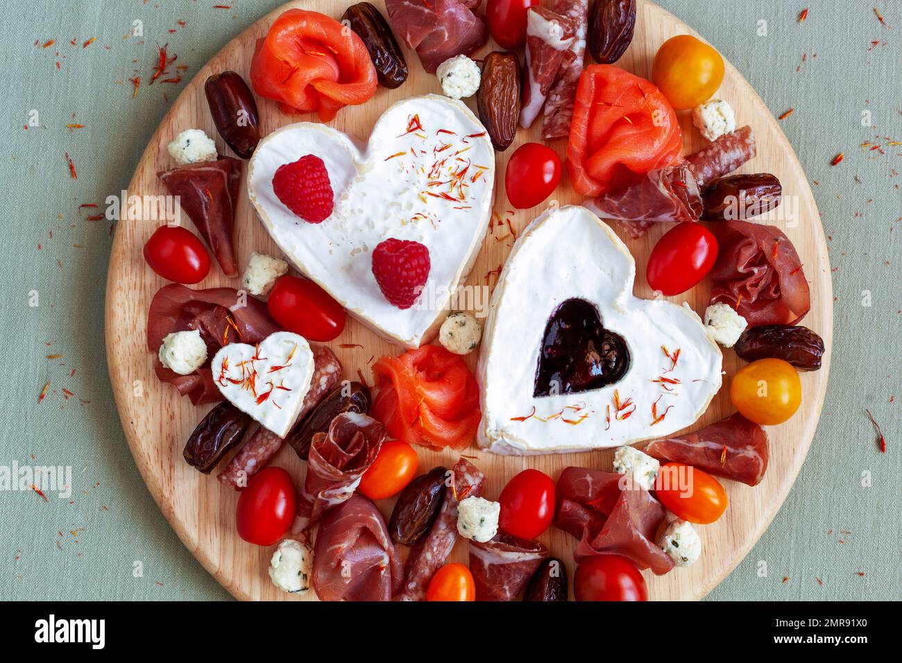 Piatto di formaggi con formaggio a forma di cuore, frutta e specialità gastronomiche Foto Stock