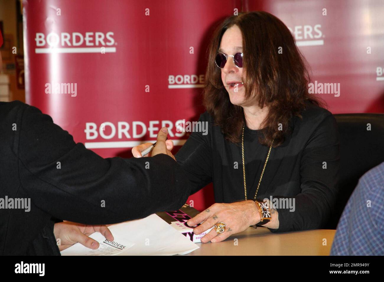 Ozzy Osbourne firma copie del suo libro 'i Am Ozzy' a Borders Books. Un giovane fan quasi non poteva essere visto sotto il tavolo, ma Ozzy si assicurò che avesse firmato il suo libro mentre lui si alzava con lui. New York, NY 1/26/2010 Foto Stock