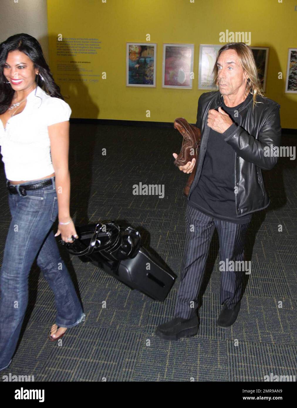 Esclusivo!! La rock star Iggy Pop arriva all'aeroporto di Miami con la sua ragazza Nina Alu. Pop sembrava avere difficoltà a camminare come aveva un grave limp. Miami, Florida 4/2/09. . . Foto Stock