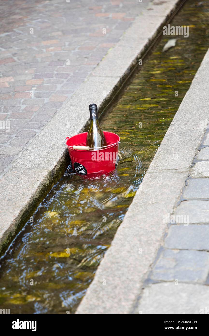 Bottiglia di vino in un secchio per il raffreddamento in Bächle, Friburgo in Breisgau, Baden-Württemberg, Germania, Europa Foto Stock