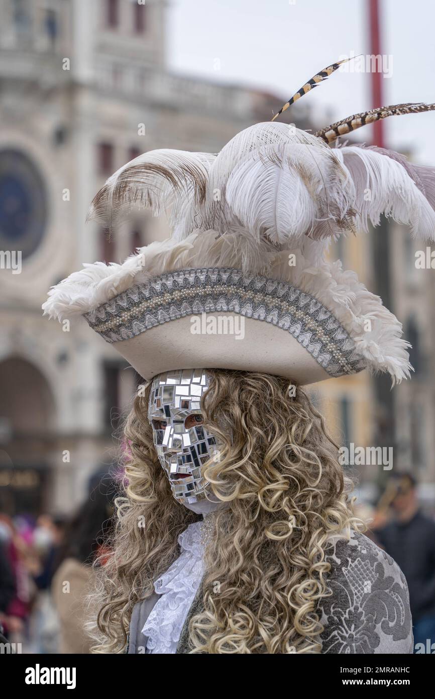 Un uomo in maschera fatto di pezzi di uno specchio, in un gilet medievale e  un cappello con piume al carnevale di Venezia Foto stock - Alamy