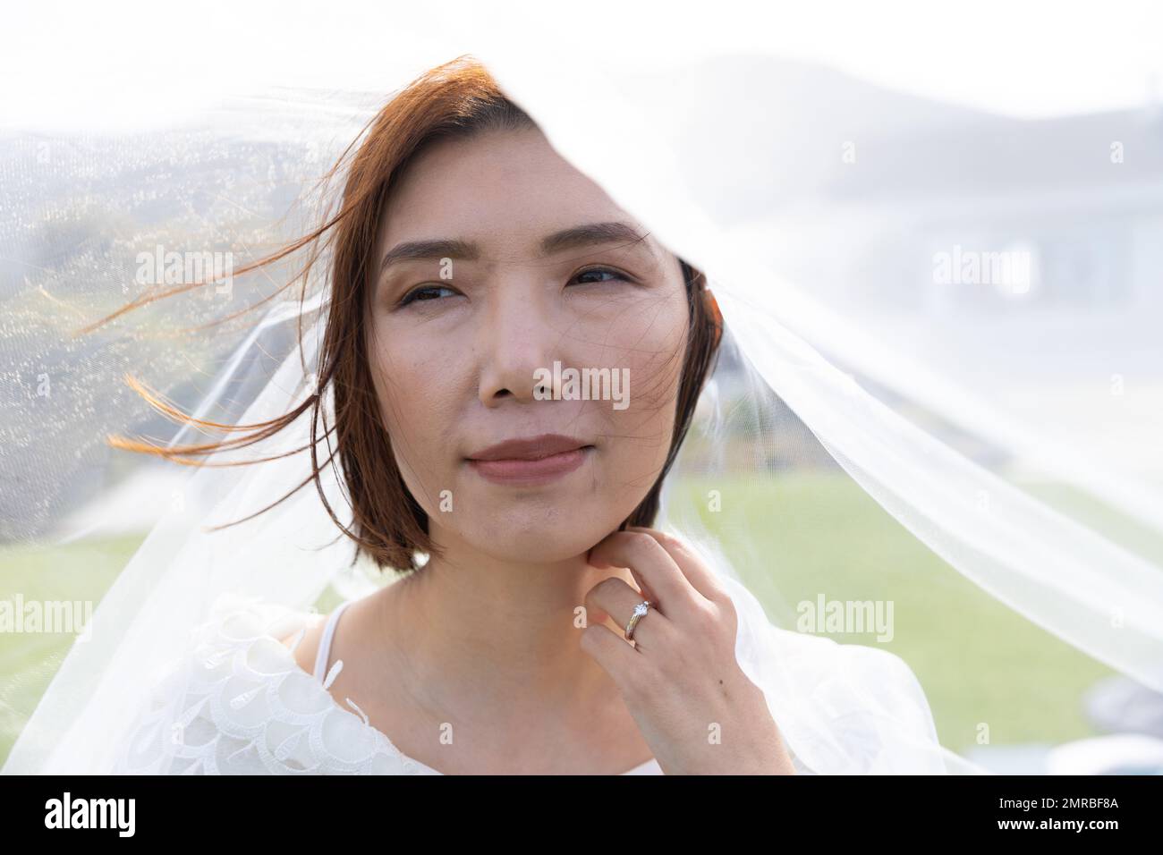 Ritratto della sposa asiatica che indossa il velo alle nozze all'aperto, spazio copia Foto Stock