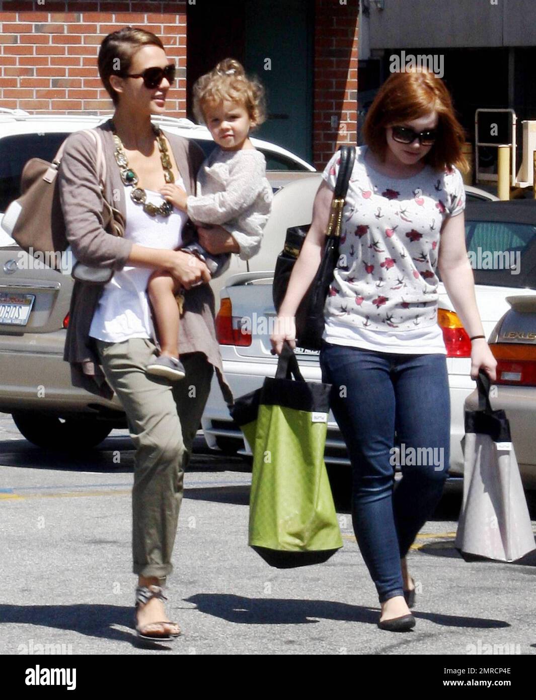 L'attrice Jessica Alba porta la figlia di 2 anni onorare Marie di nuovo alla sua auto mentre fuori con un amico per un po 'di shopping. Jessica ha preso un momento per guardare adoringly il suo piccolo prima di metterla nel SUV ibrido di Yukon. Alba, che ha una serie di film in uscita nel 2010, tra cui 'The Killer Inside Me', 'Machete' e 'Little Fockers', pantaloni trendy pieghettati e alla moda, una collana e sandali con motivi zebra. Los Angeles, California. 08/03/10. . Foto Stock