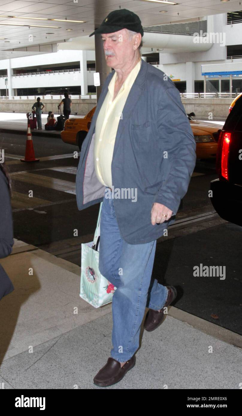 ESCLUSIVO!! Il leggendario attore, scrittore e comico britannico John Cleese, famoso per le apparizioni e la scrittura di serie televisive e film tra cui 'Monty Python's Flying Circus', 'Fawlty Towers, 'Shrek' e 'Will & Grace', arriva all'aeroporto internazionale di Miami per prendere un volo. Cleese si assicurò di portare fuori dai bagagli quello che sembrava essere un nuovo computer portatile Apple, riponendolo in una borsa a mano. Miami, Florida. 3/10/11. Foto Stock