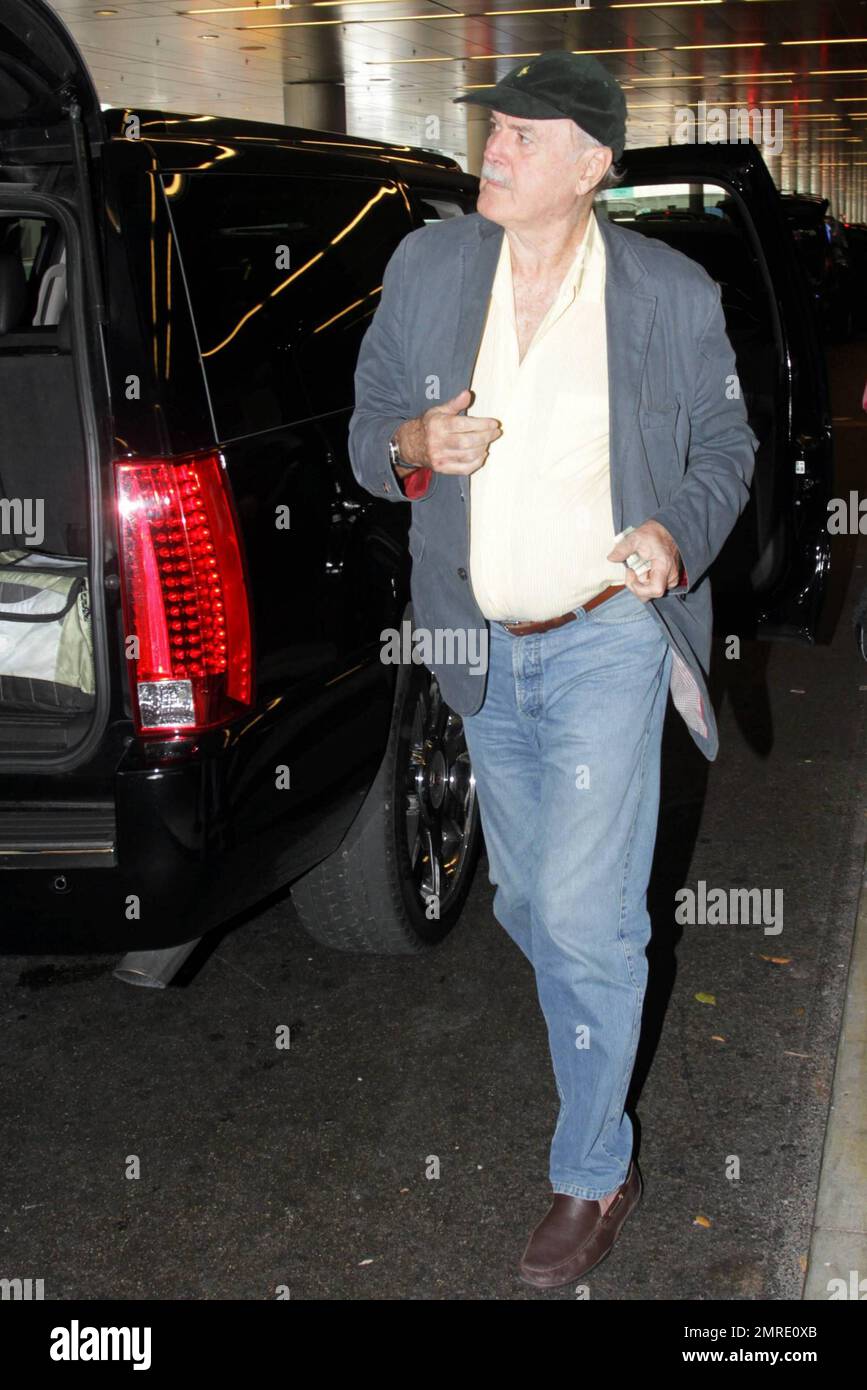 ESCLUSIVO!! Il leggendario attore, scrittore e comico britannico John Cleese, famoso per le apparizioni e la scrittura di serie televisive e film tra cui 'Monty Python's Flying Circus', 'Fawlty Towers, 'Shrek' e 'Will & Grace', arriva all'aeroporto internazionale di Miami per prendere un volo. Cleese si assicurò di portare fuori dai bagagli quello che sembrava essere un nuovo computer portatile Apple, riponendolo in una borsa a mano. Miami, Florida. 3/10/11. Foto Stock