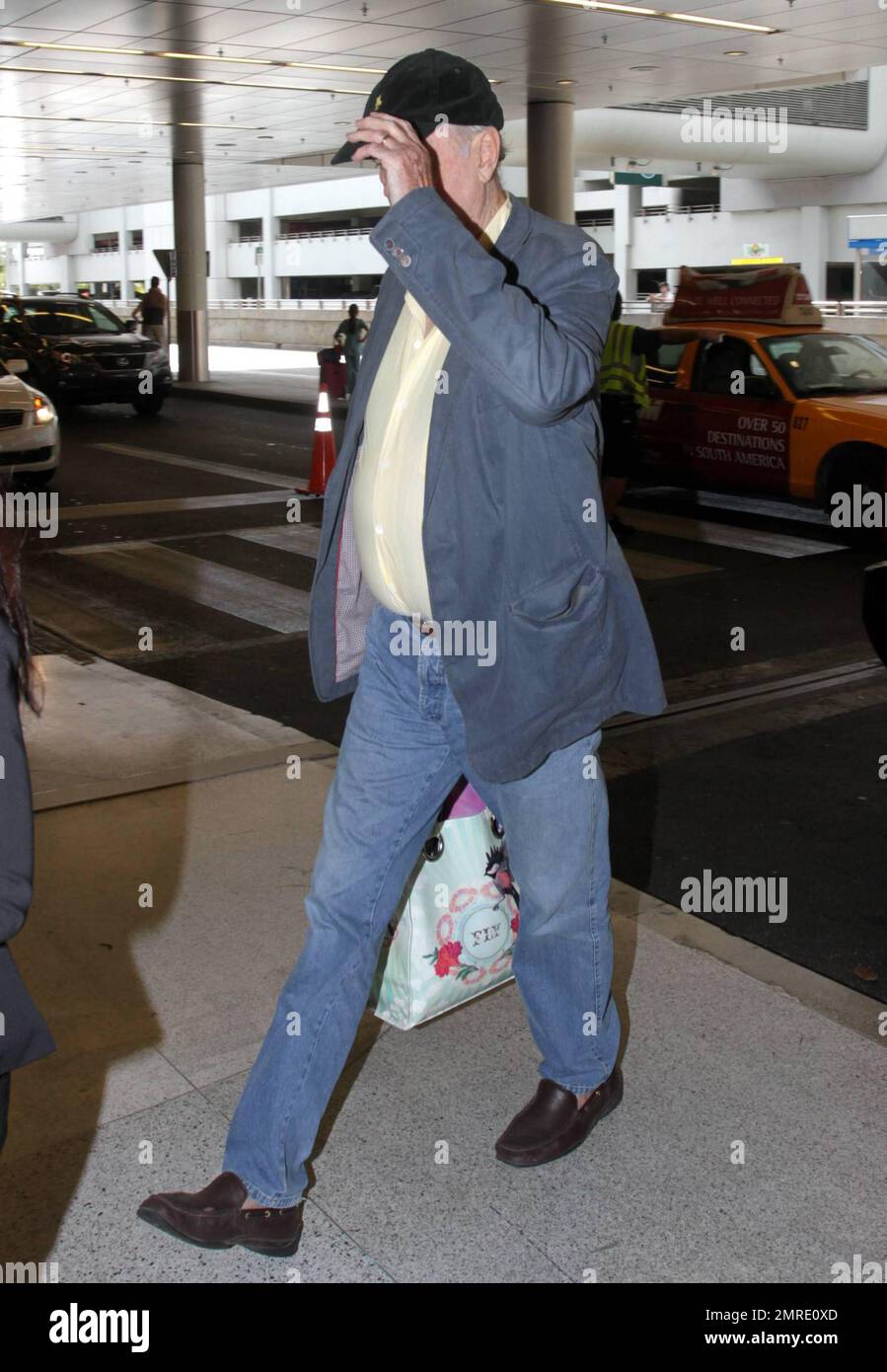 ESCLUSIVO!! Il leggendario attore, scrittore e comico britannico John Cleese, famoso per le apparizioni e la scrittura di serie televisive e film tra cui 'Monty Python's Flying Circus', 'Fawlty Towers, 'Shrek' e 'Will & Grace', arriva all'aeroporto internazionale di Miami per prendere un volo. Cleese si assicurò di portare fuori dai bagagli quello che sembrava essere un nuovo computer portatile Apple, riponendolo in una borsa a mano. Miami, Florida. 3/10/11. Foto Stock