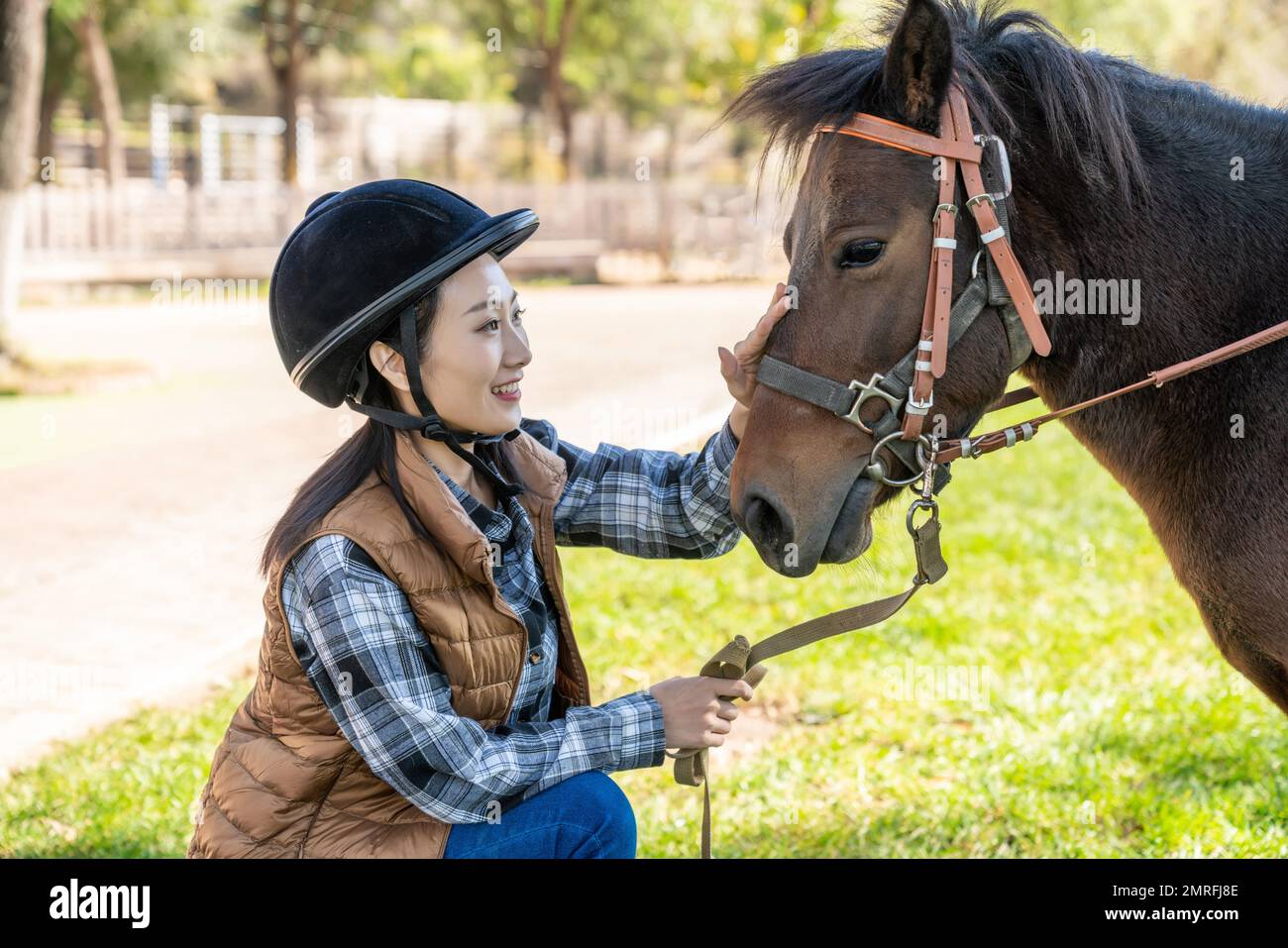 La giovane donna che cavalca un cavallo Foto Stock