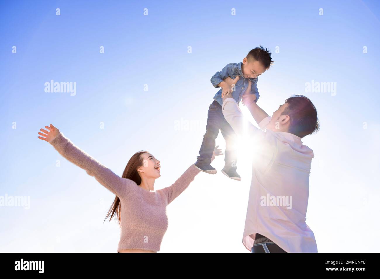 Felice famiglia asiatica in piedi e giocare con il figlio Foto Stock