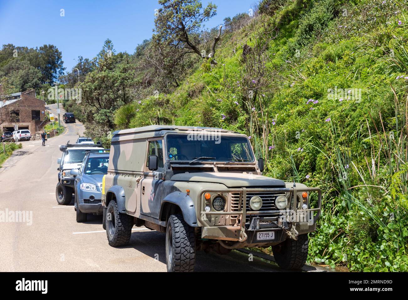 1989 modello Land Rover Defender 110 in colori dell'esercito parcheggiato a Warriewood Beach a Sydney, NSW, Australia Foto Stock
