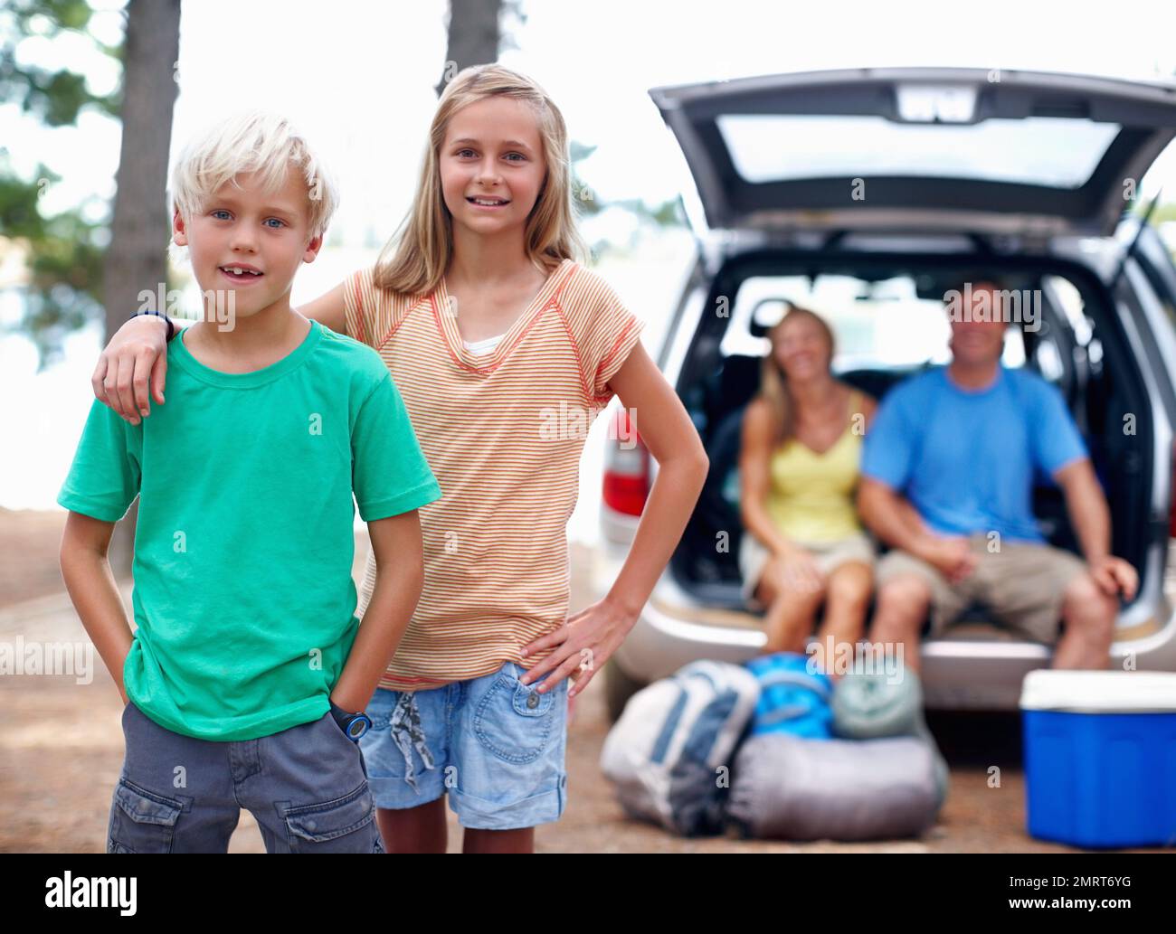 Vacanza in famiglia. Ritratto di giovane fratello e sorella godendo la loro vacanza con i genitori seduti sul retro di una macchina. Foto Stock