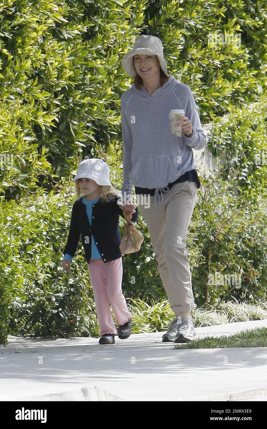 L'attrice marcia Cross va per una passeggiata informale con la figlia che prende il bel sole della domenica. Croce vestita in un elegante pullover a righe felpa con cappuccio, arrotolato khakis e lei e sua figlia indossavano cappelli corrispondenti. Dopo aver preso un caffè con le sue sneakers, Cross in seguito cambiò con i suoi sandali e portò una semplice borsa tote CŽline in pelle e tessuto di design. Cross è la madre di due graziose figlie gemelle Eden e Savannah. Los Angeles, California. 03/13/11. Foto Stock