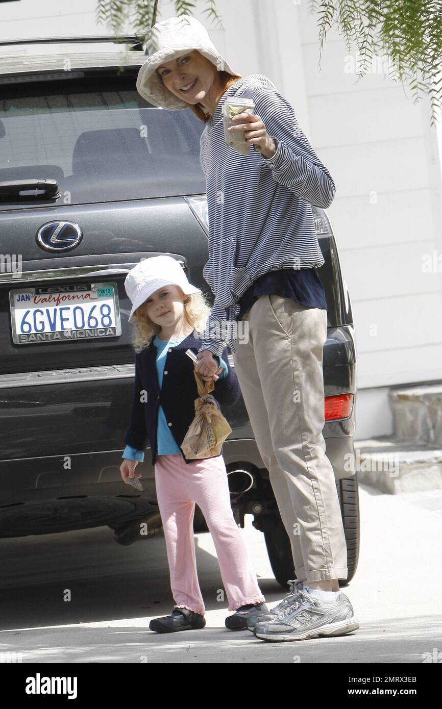 L'attrice marcia Cross va per una passeggiata informale con la figlia che prende il bel sole della domenica. Croce vestita in un elegante pullover a righe felpa con cappuccio, arrotolato khakis e lei e sua figlia indossavano cappelli corrispondenti. Dopo aver preso un caffè con le sue sneakers, Cross in seguito cambiò con i suoi sandali e portò una semplice borsa tote CŽline in pelle e tessuto di design. Cross è la madre di due graziose figlie gemelle Eden e Savannah. Los Angeles, California. 03/13/11. Foto Stock