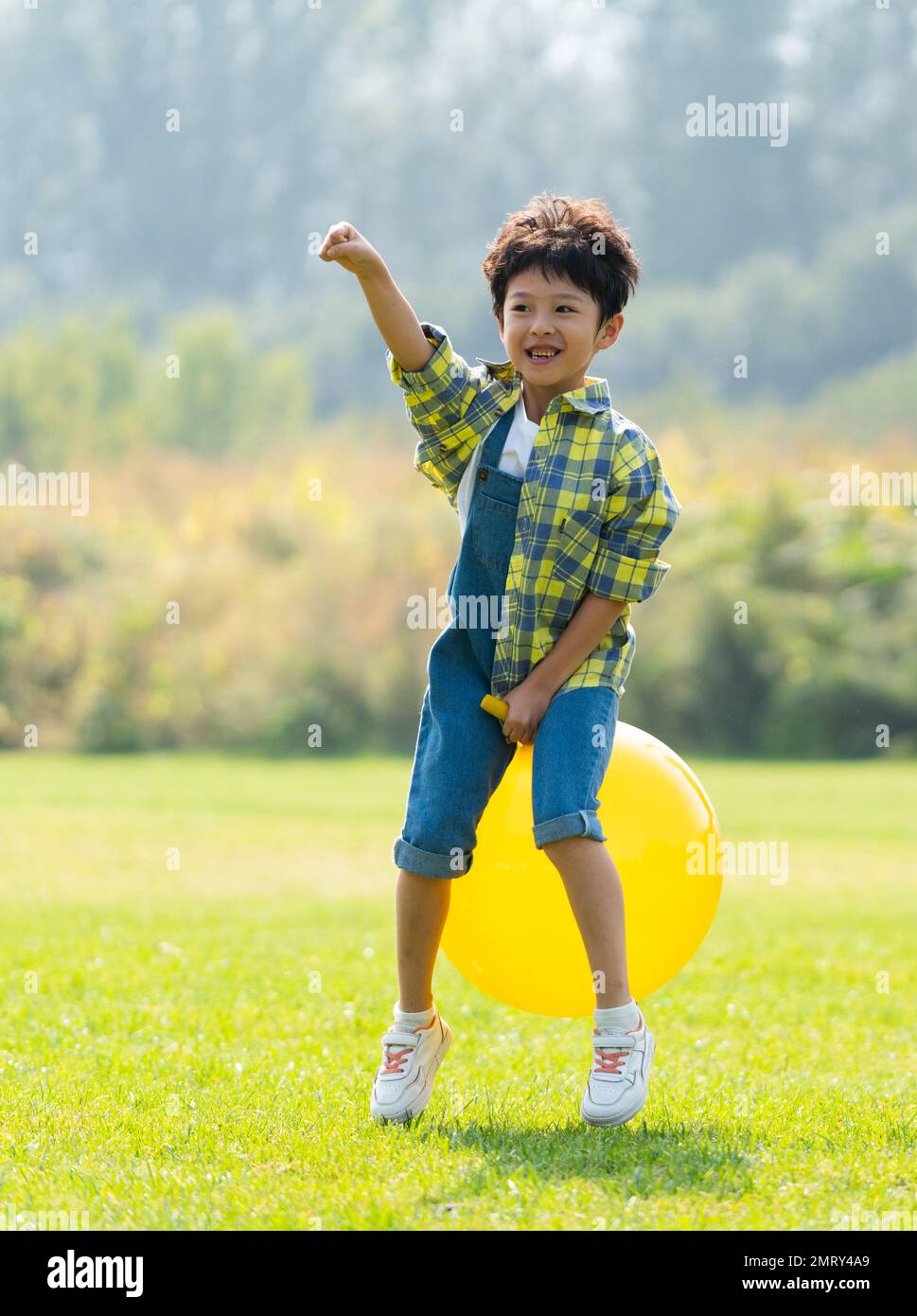 Un ragazzino che gioca sulla palla d'erba Foto Stock