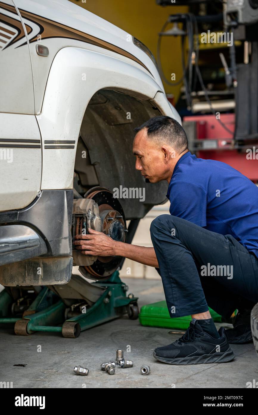 Lushui, provincia cinese dello Yunnan. 21st Ott 2022. Yang Mingjin cambia un pneumatico a Lushui City, Prefettura autonoma di Lisu di Nujiang, Provincia Yunnan della Cina sudoccidentale, 21 ottobre 2022. PER ANDARE CON 'Profilo: Il proprietario del negozio di pneumatici illumina le montagne con i film' credito: HU Chao/Xinhua/Alamy Live News Foto Stock