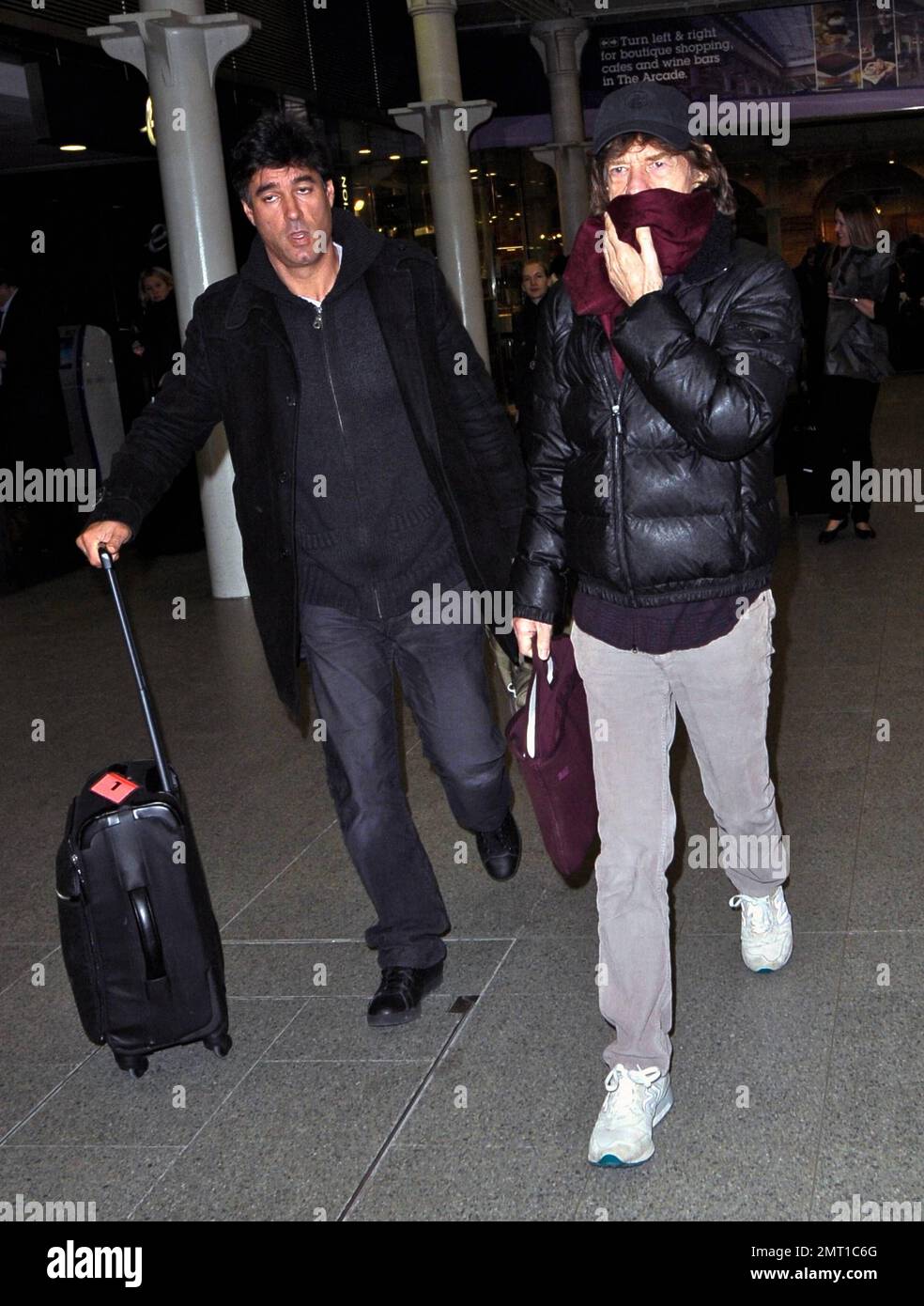 Rolling Stones ROCKER Mick Jagger si copre con una sciarpa dopo l'arrivo da Parigi sull'Eurostar. Londra, Regno Unito. 7th dicembre 2011. Foto Stock