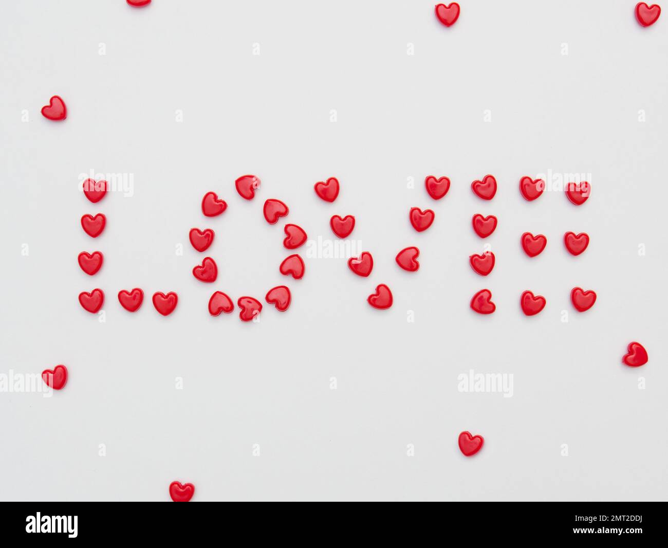 Parola d'amore fatto piccolo cuore rosso su sfondo bianco per San Valentino. Foto Stock