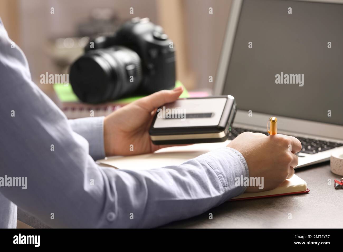 Giornalista con registratore vocale al tavolo in ufficio, in primo piano Foto Stock