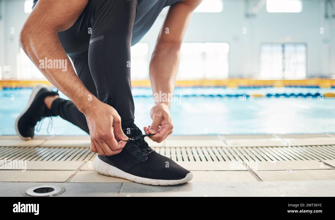 Fitness, scarpe e uomo che si preparano per l'allenamento, l'esercizio fisico o la corsa con sneakers sportivi, moda ed energia. Piedi di un atleta, corridore o persona Foto Stock
