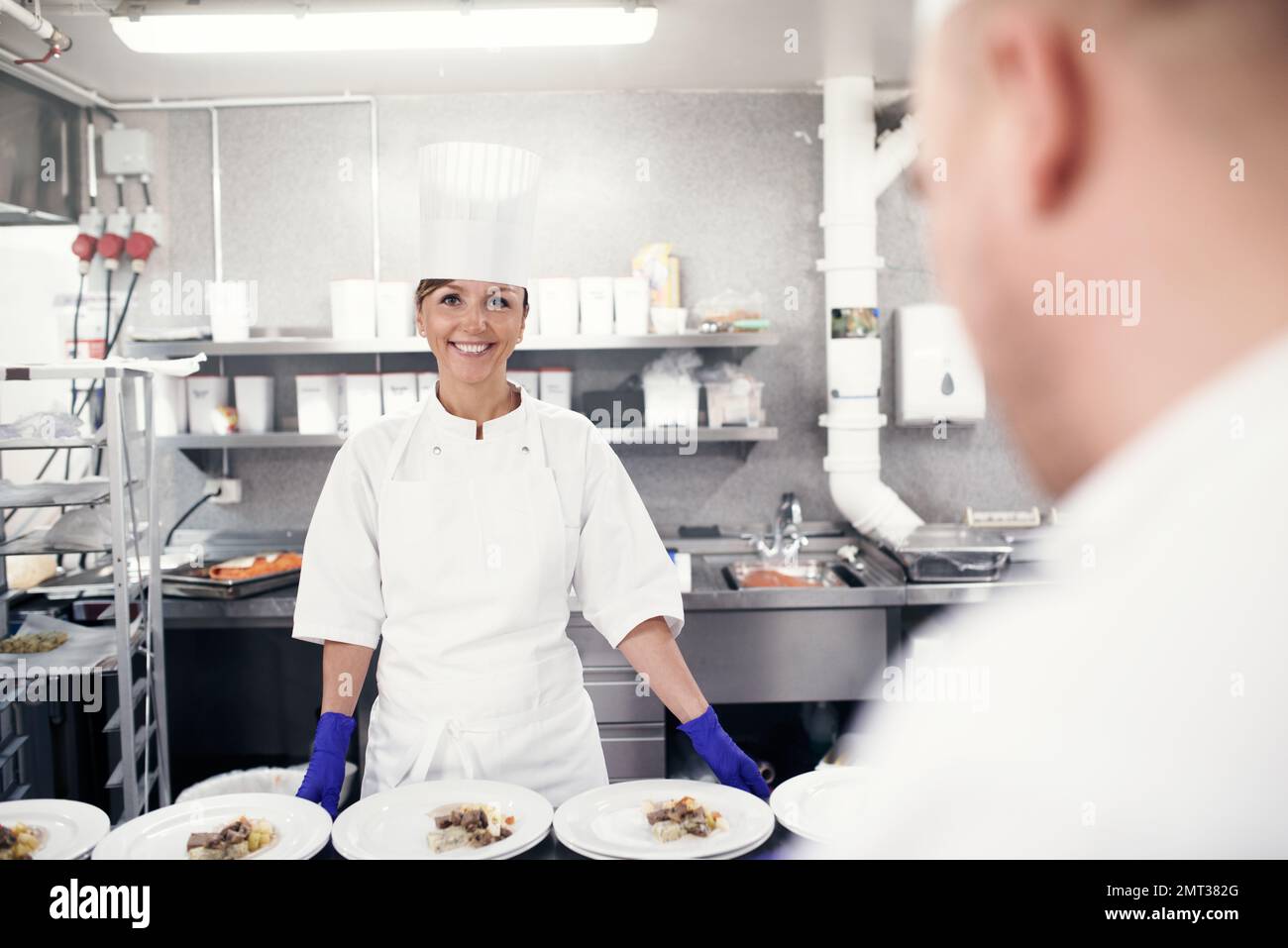 Preparato e pronto per l'uso. chef che preparano un servizio di pasto in una cucina professionale. Foto Stock