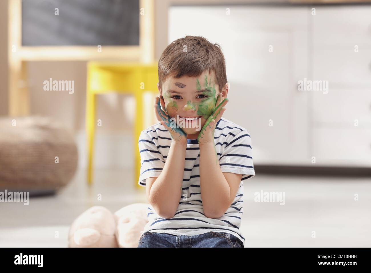 Bambino felice con vernice sul viso in camera Foto Stock