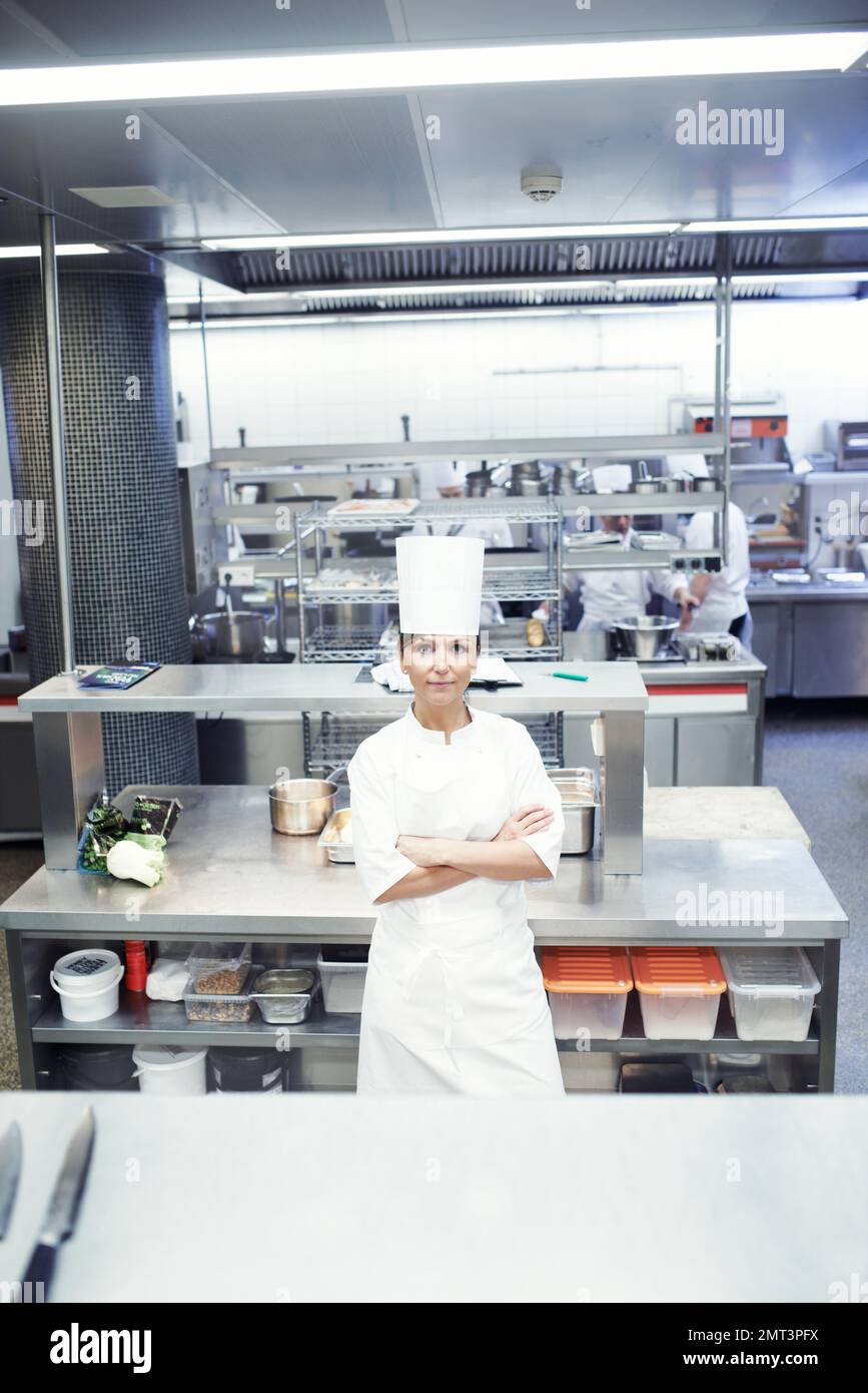 Dalla mia cucina al vostro tavolo da pranzo. Ritratto di uno chef in una cucina professionale. Foto Stock