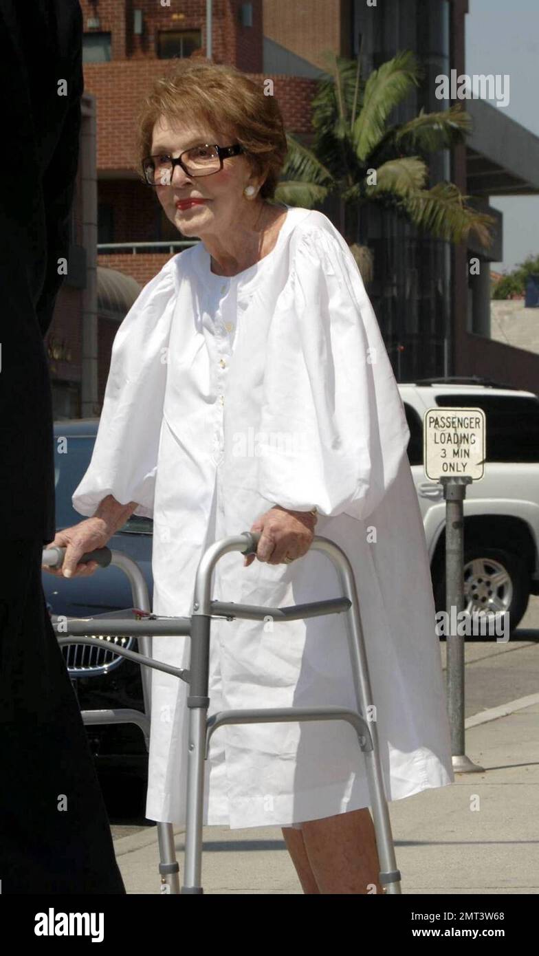 L'ex First Lady Nancy Reagan, vestita in modo impeccabile, lascia un edificio medico a piedi con l'aiuto di un camminatore e di un agente del Servizio Segreto che la aiutò a scendere in un marciapiede. Los Angeles, California. 9/3/09. Foto Stock