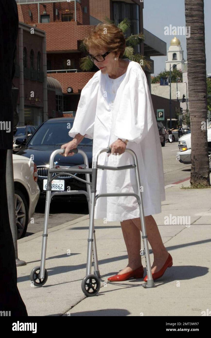 L'ex First Lady Nancy Reagan, vestita in modo impeccabile, lascia un edificio medico a piedi con l'aiuto di un camminatore e di un agente del Servizio Segreto che la aiutò a scendere in un marciapiede. Los Angeles, California. 9/3/09. Foto Stock