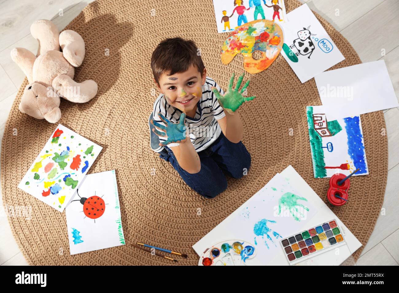 Bambino piccolo con pittura sul viso e palme in camera, vista dall'alto Foto Stock