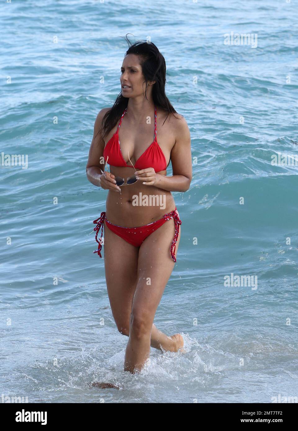 Padma Lakshmi sembra sbalorditivo in un bikini a corda rossa mentre fa un tuffo nell'oceano di Miami. Miami Beach, Florida. Febbraio 8, 2015. Foto Stock