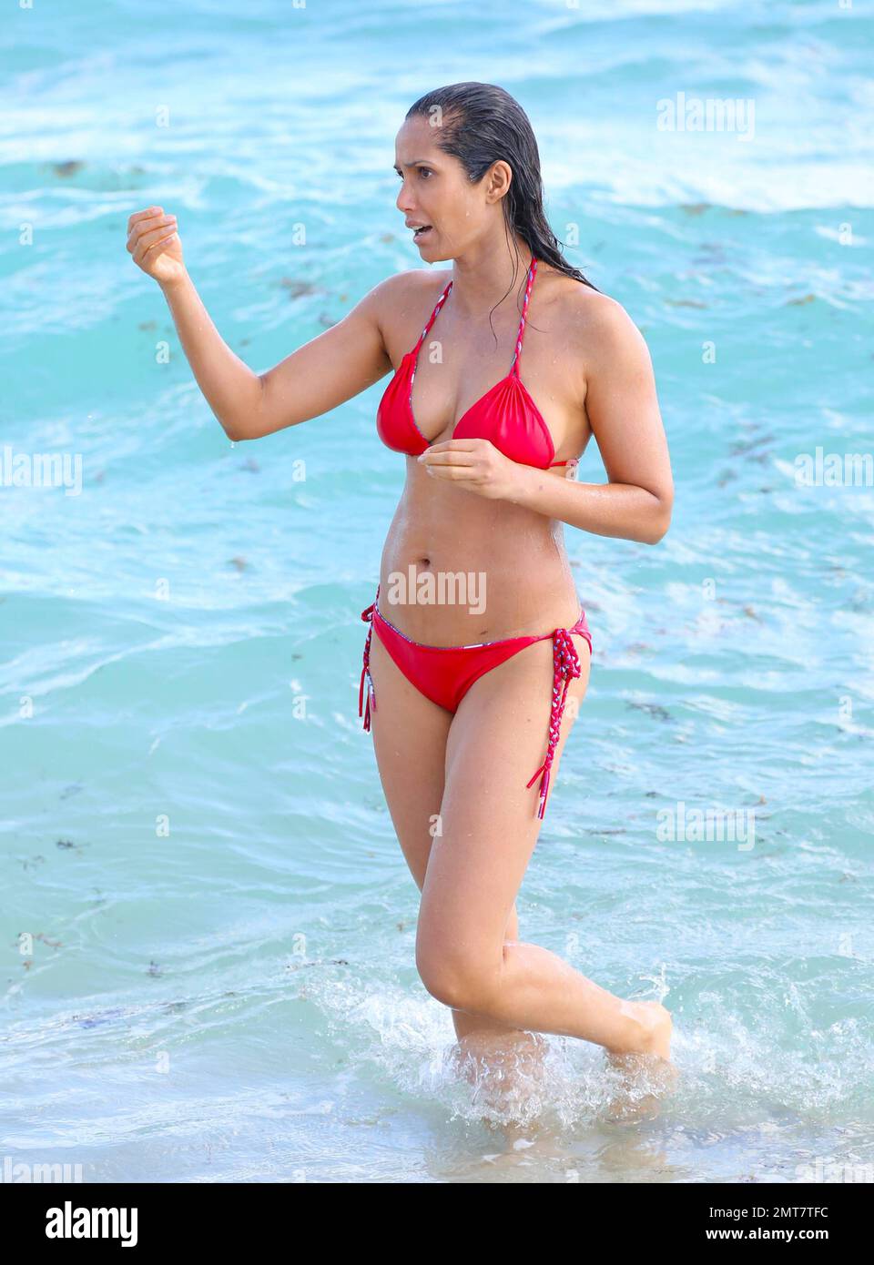 Padma Lakshmi sembra sbalorditivo in un bikini a corda rossa mentre fa un tuffo nell'oceano di Miami. Miami Beach, Florida. Febbraio 8, 2015. Foto Stock