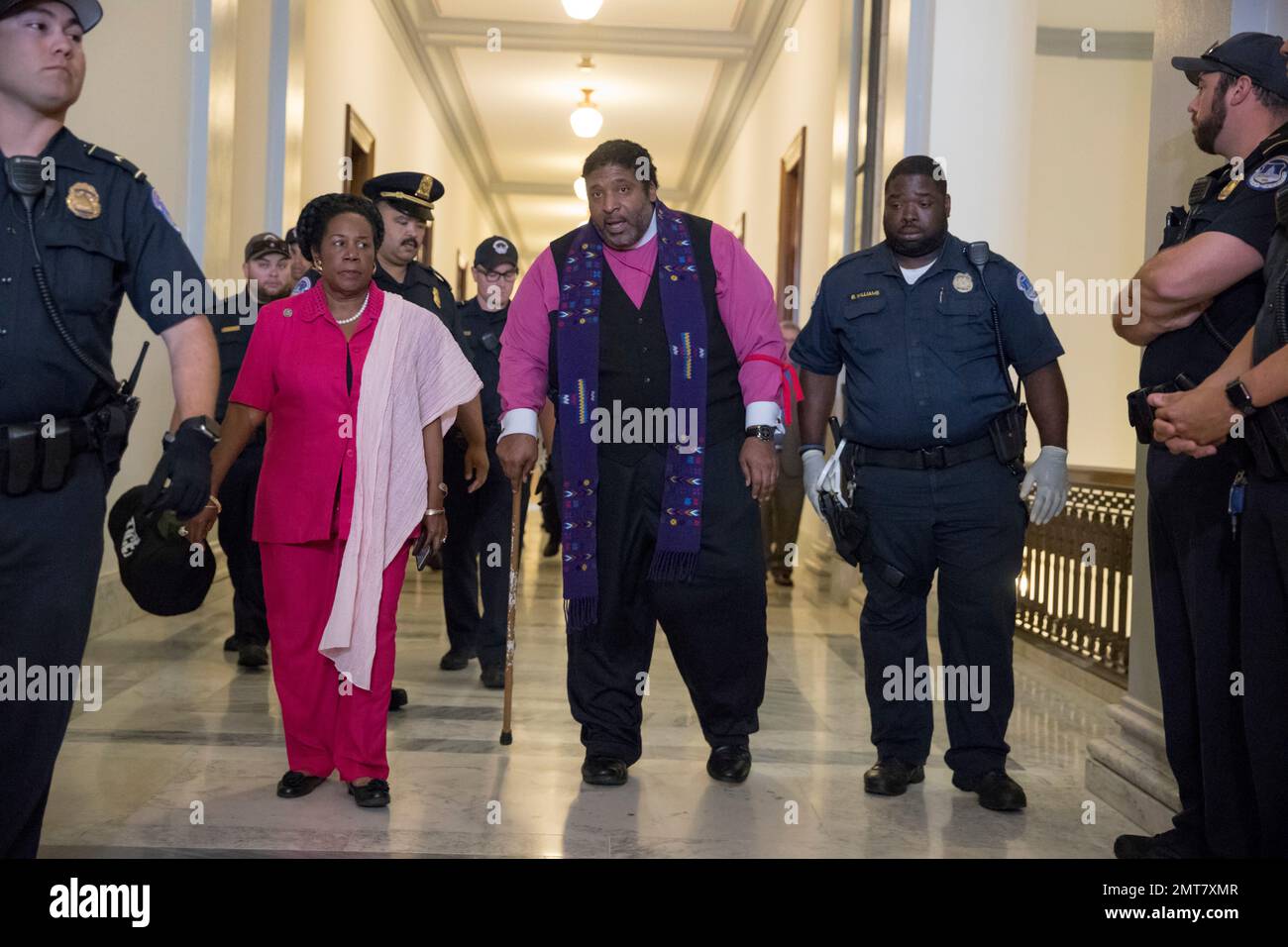North Carolina NAACP President Rev. William Barber, accompanied by Rep. Sheila Jackson Lee, Texas, left, are taken into custody by U.S. Capitol Police on Capitol Hill in Washington, Thursday, July 13, 2017, after protesting against the Republican health care bill outside the office of Senate Majority Leader Mitch McConnell of Ky. (AP Photo/J. Scott Applewhite) Foto Stock