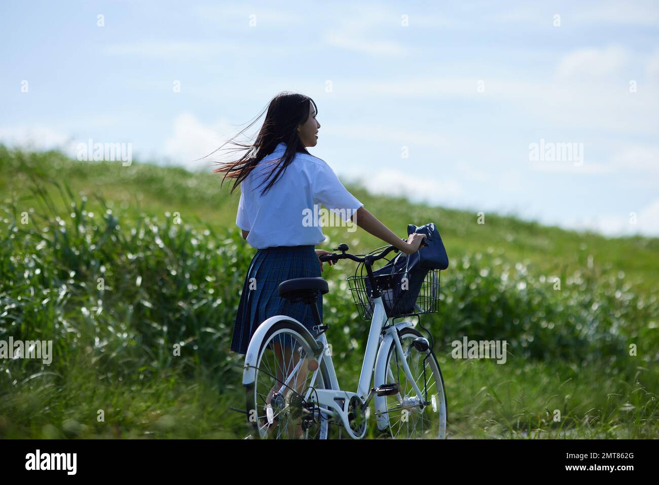 Studente di scuola superiore giapponese in bicicletta all'aperto Foto Stock