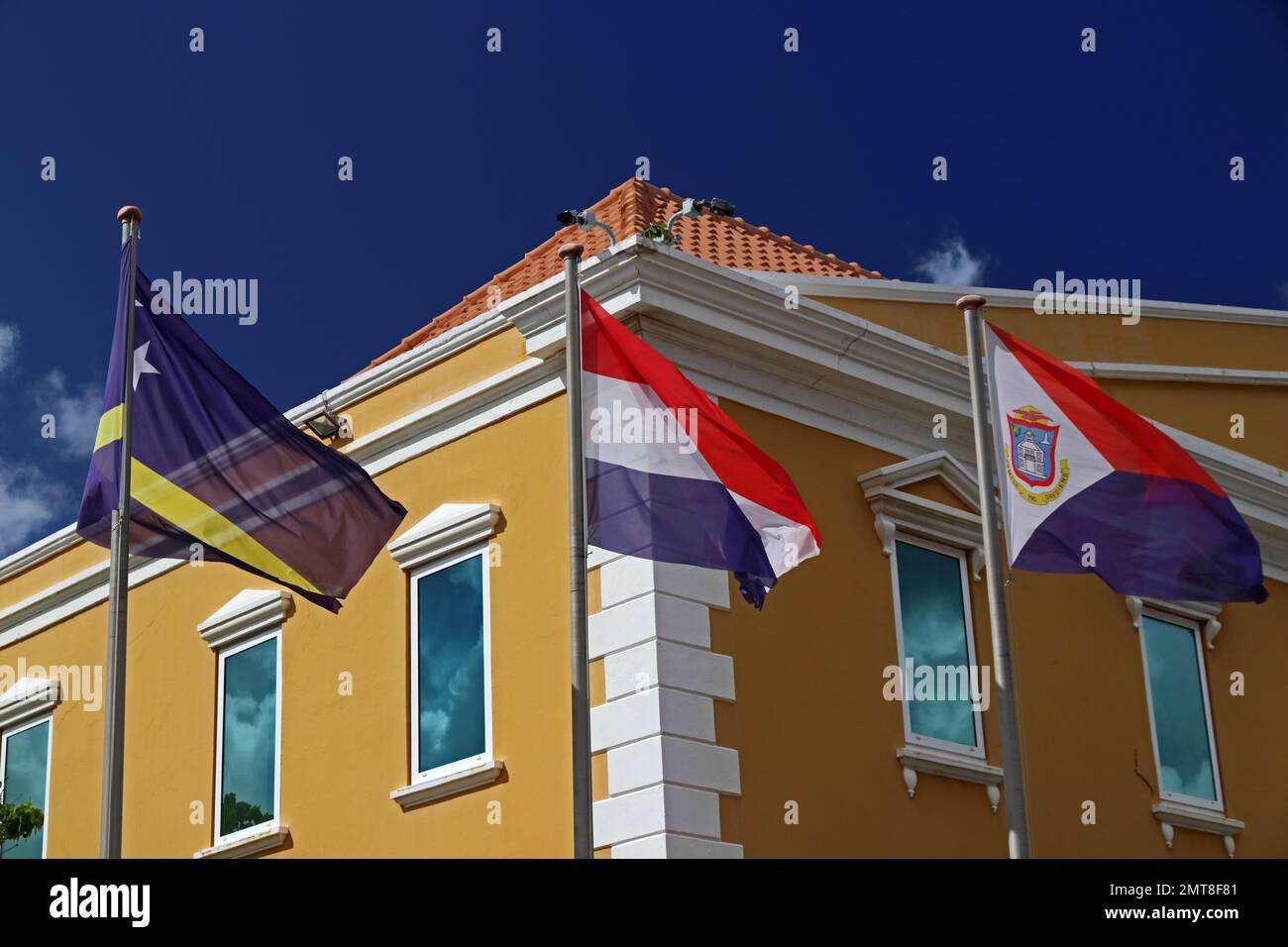 Bandiere nazionali di Curacao, Olanda e Sint Maarten che volano al di fuori dell'edificio governativo, Willamstadt, Curacao Foto Stock