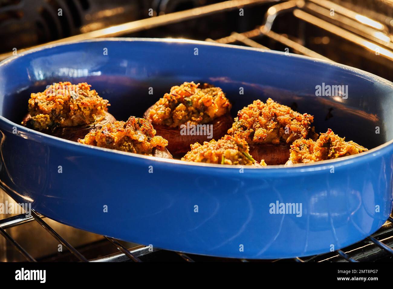 I funghi farciti vengono cotti in forno in piatti di ceramica. Foto Stock