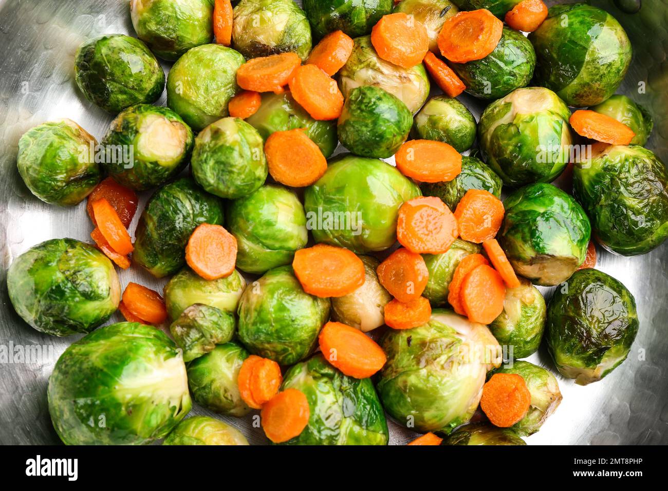 Germogli di Bruxelles arrosto con carota in padella, primo piano Foto Stock