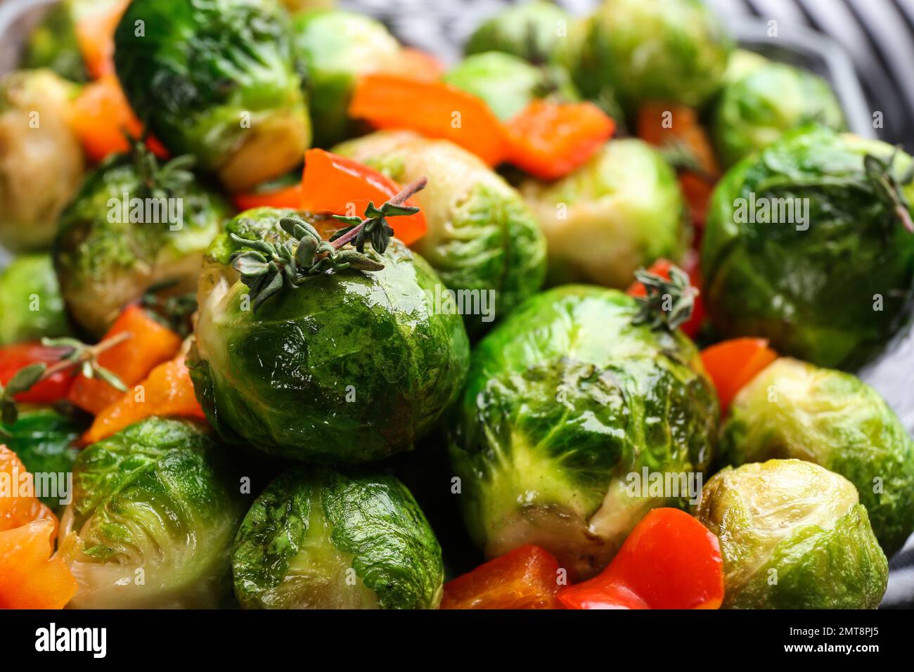 Deliziosi germogli di Bruxelles arrostiti con peperone di fondo, primo piano Foto Stock