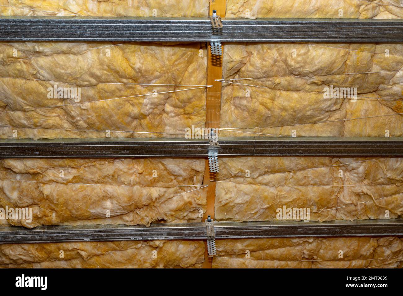 Telaio in alluminio con appendiabiti disposti su travi in soffitta per il montaggio di cartongesso. Foto Stock