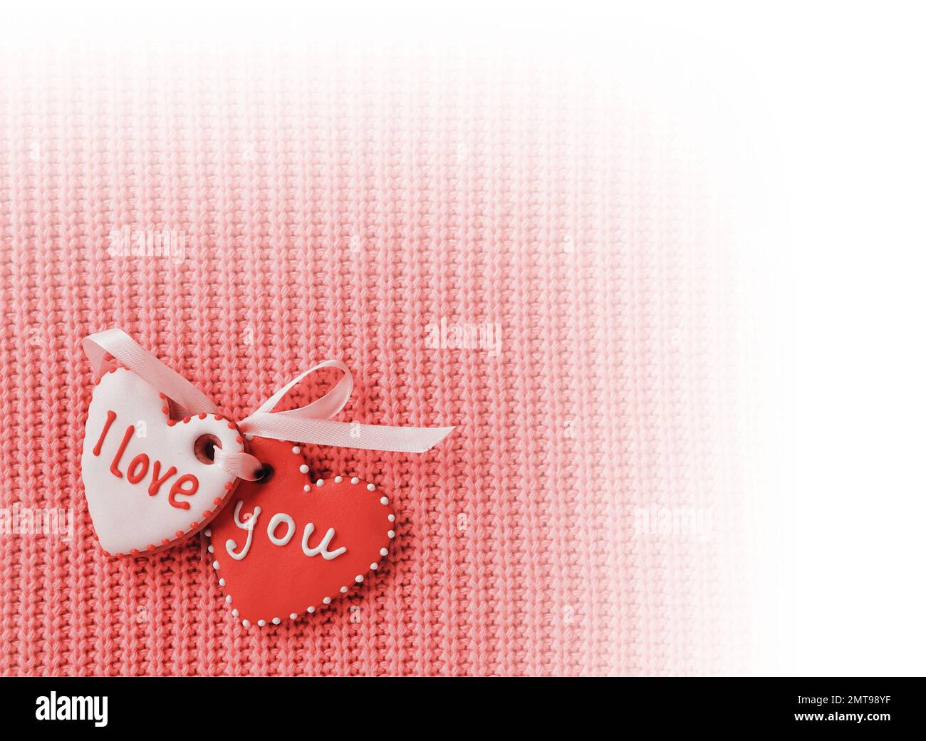 Due biscotti a forma di cuore che fanno l'iscrizione i love you su uno sfondo rosso. Design a vignetta bianco. Vista dall'alto. Biglietto d'auguri Foto Stock