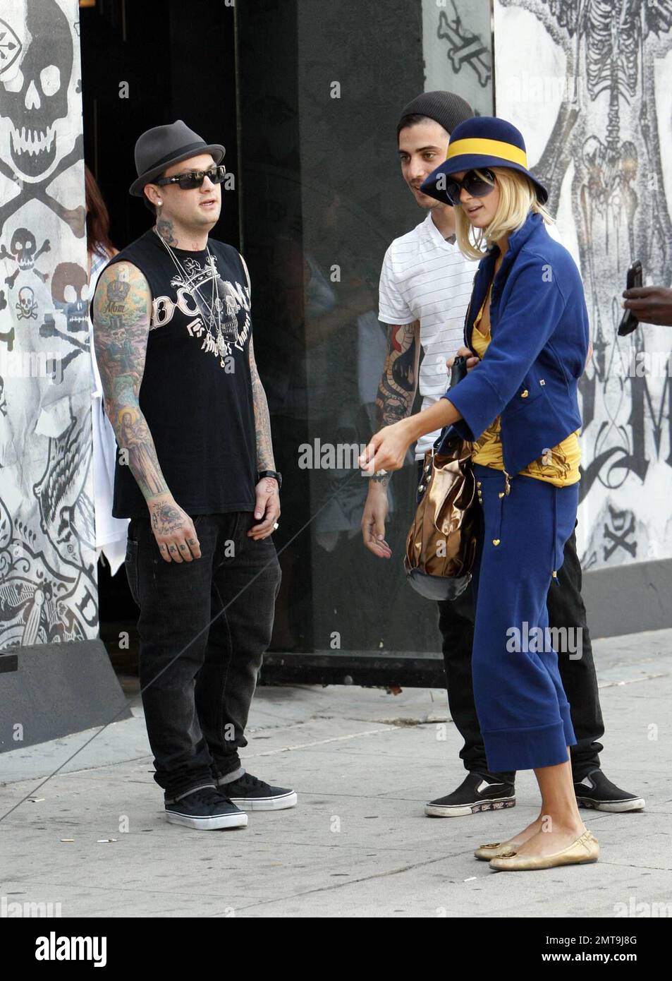 Una di queste cose non è come le altre! Paris Hilton, con il suo piccolo cane al traino, sembra un po' fuori posto con il suo abito colorato e il grande cappello blu mentre lei e il ragazzo Benji Madden fanno una sosta per fare shopping al negozio Benji, il DCMA Collective. Hollywood, California. 5/20/08. Foto Stock