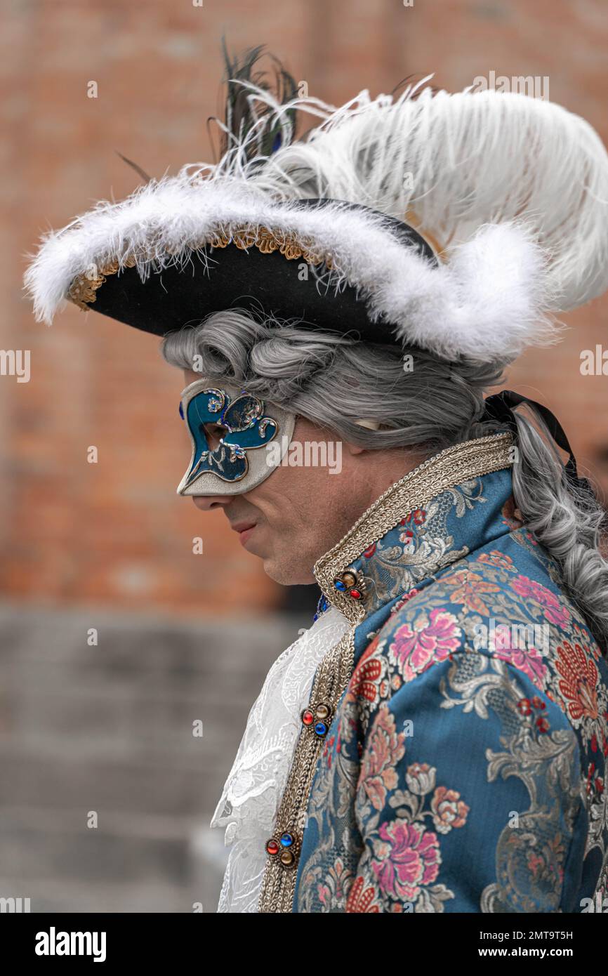 Un uomo di mezza età in costume vintage con colletto in pizzo, con maschera  carnevale, cappello a tricorno con piume, si erge in profilo al carnevale  Foto stock - Alamy
