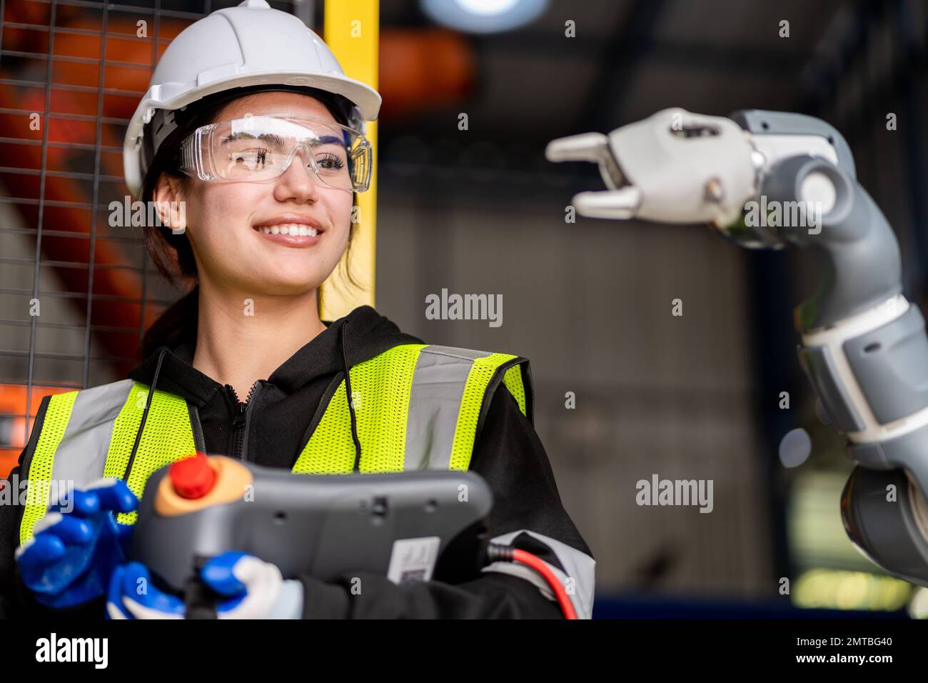 Un team di ingegneri maschili e femminili si riunisce per ispezionare i robot di saldatura dell'acciaio controllati dal computer. Pianificare le prove e l'installazione per l'uso. Foto Stock