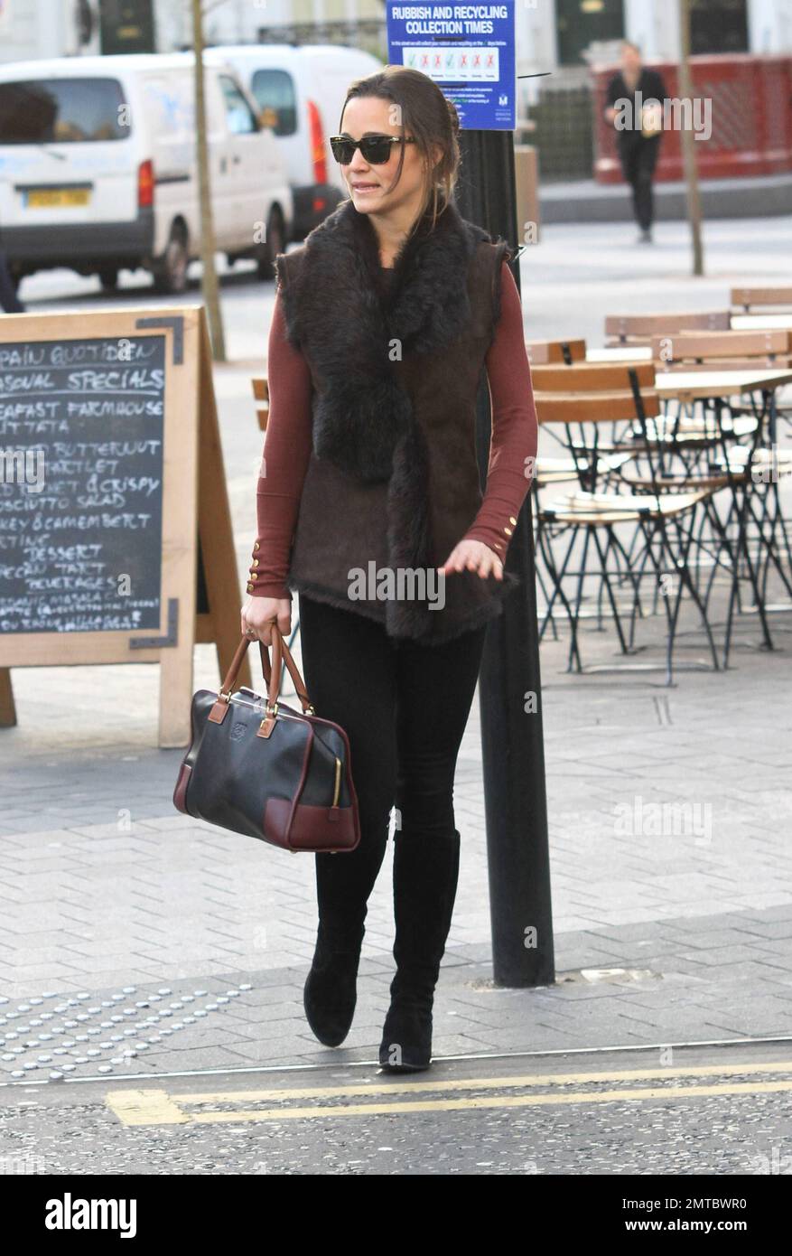 Pippa Middleton è stato visto camminare per lavorare in un gilet marrone  con un colletto in pelliccia, top marrone, leggings neri e accessoriati con  occhiali da sole scuri, borsa nera e stivali
