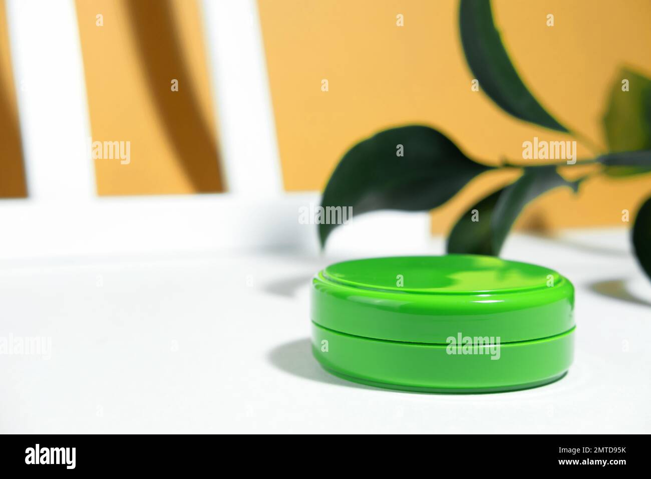 Lo sfondo è cosmetico. Contenitore vuoto verde Moquet con crema viso idratante o protettiva isolato su fondo autunno bianco beige con pla Foto Stock