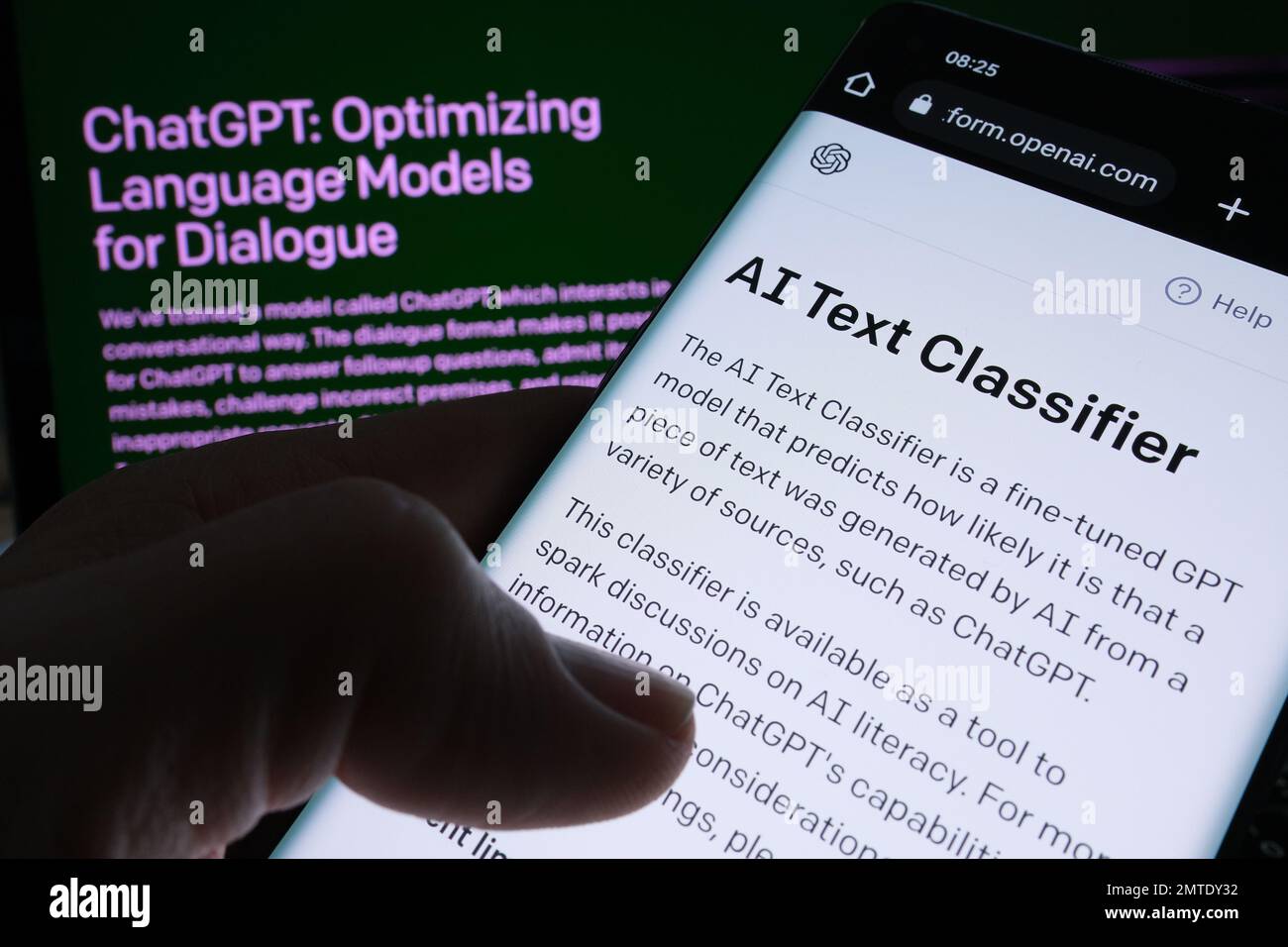 Pagina Web del software ai Text Classifier visualizzata sullo schermo dello smartphone e sulla pagina ChatGPT sullo sfondo sfocato. Strumento per il rilevamento di testo scritto ai tramite OPEN A. Foto Stock