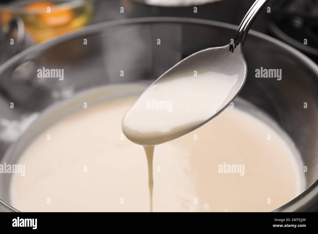 Versare l'impasto per i waffle belgi su una ciotola di vetro e un primo piano Foto Stock