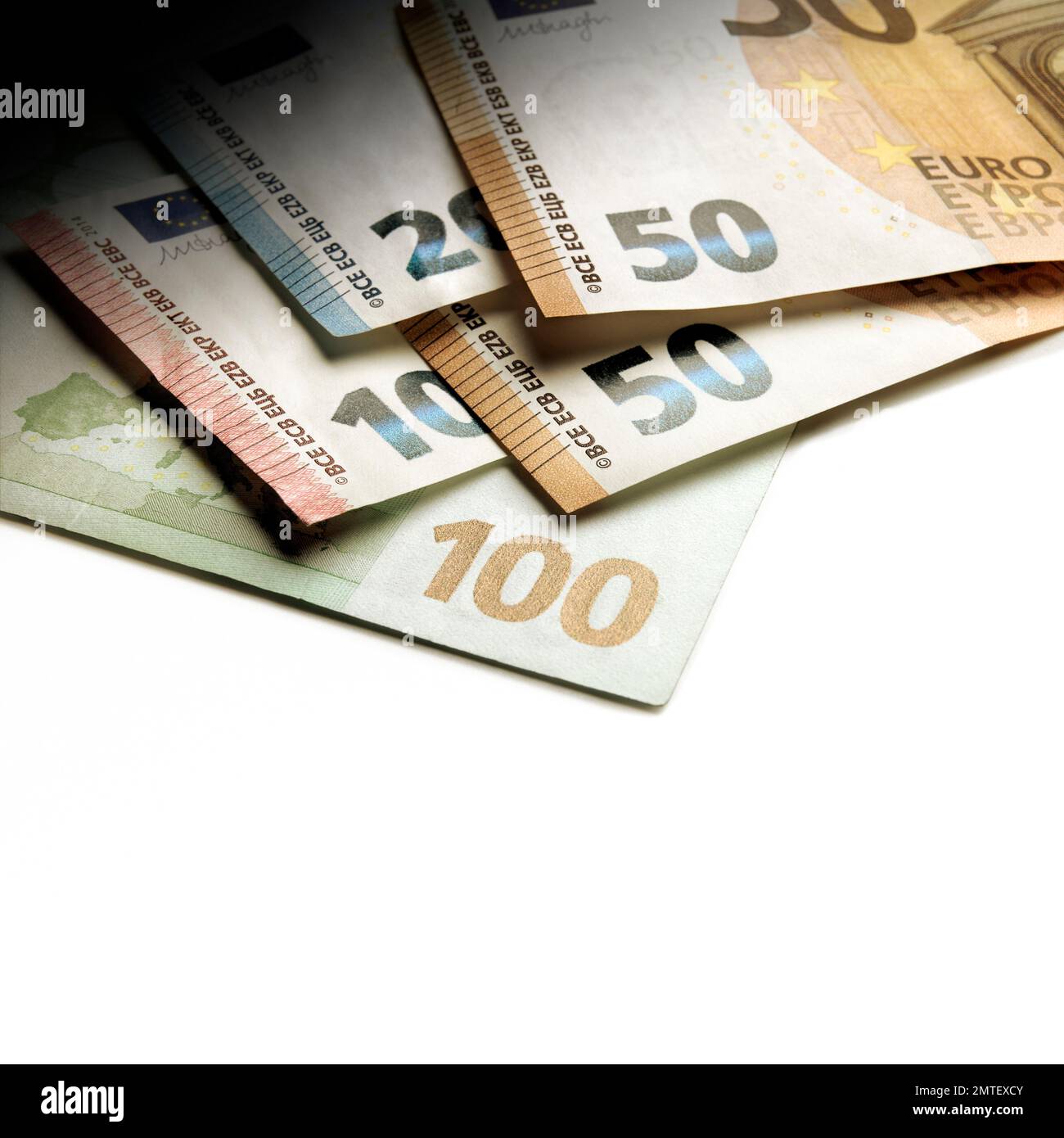Messa a fuoco superficiale contro un mucchio di banconote in euro usate valori diversi con un effetto luce spot e uno spazio di copia Foto Stock