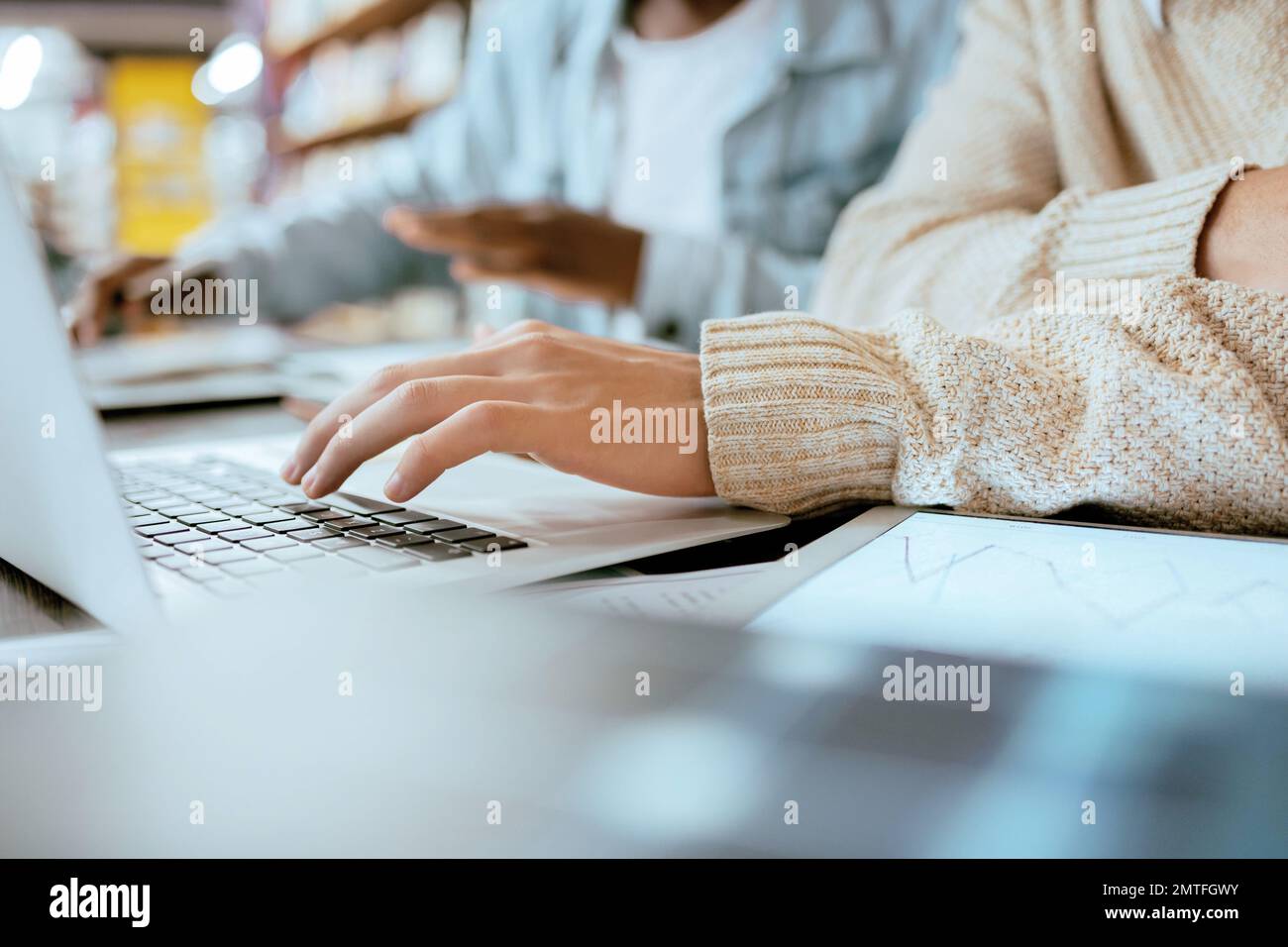 Mani, computer portatile e tastiera per la ricerca, la navigazione o l'apprendimento nella libreria del campus. Mano di studente che lavora, studia o scrive progetto Foto Stock